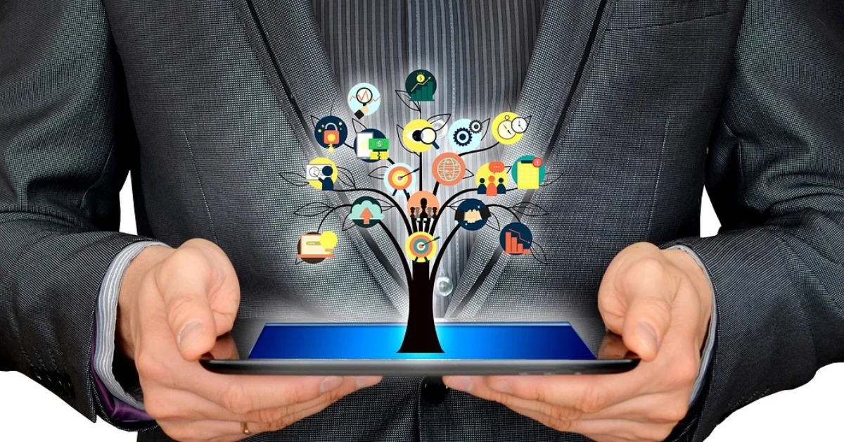 Image of a man holds a tablet with a glowing tree of business ideas.