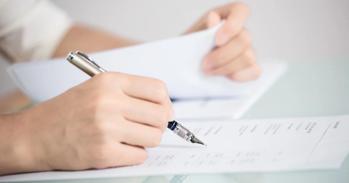 Image of businessperson signing official DMCC license application documents in Dubai.