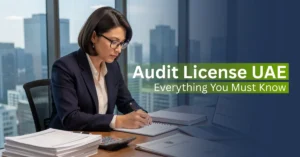 Licensed auditor reviewing financial documents in a UAE office explaining audit license requirements for businesses
