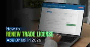 Business manager reviewing trade license renewal online in Abu Dhabi office.