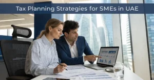 Tax Planning strategies for SMEs in UAE with business owner reviewing financial reports and corporate tax planning.